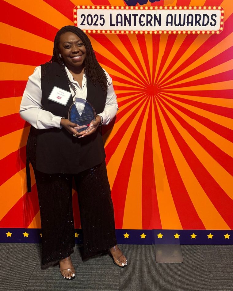 Brittany Davis Morris holding her award at the 2025 Lantern Awards